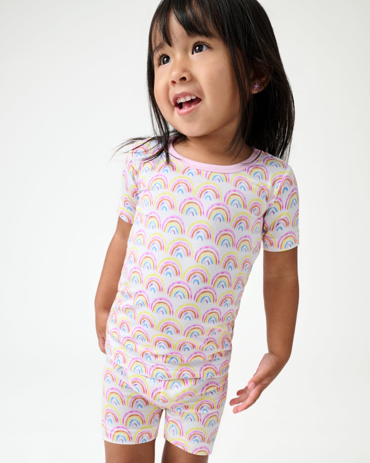 Close up of girl wearing the Pastel Rainbows Two-Piece Short Sleeve & Shorts Pajama Set