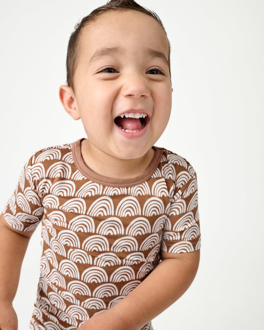 Close up of boy wearing the Rust Rainbows Two-Piece Short Sleeve & Shorts Pajama Set