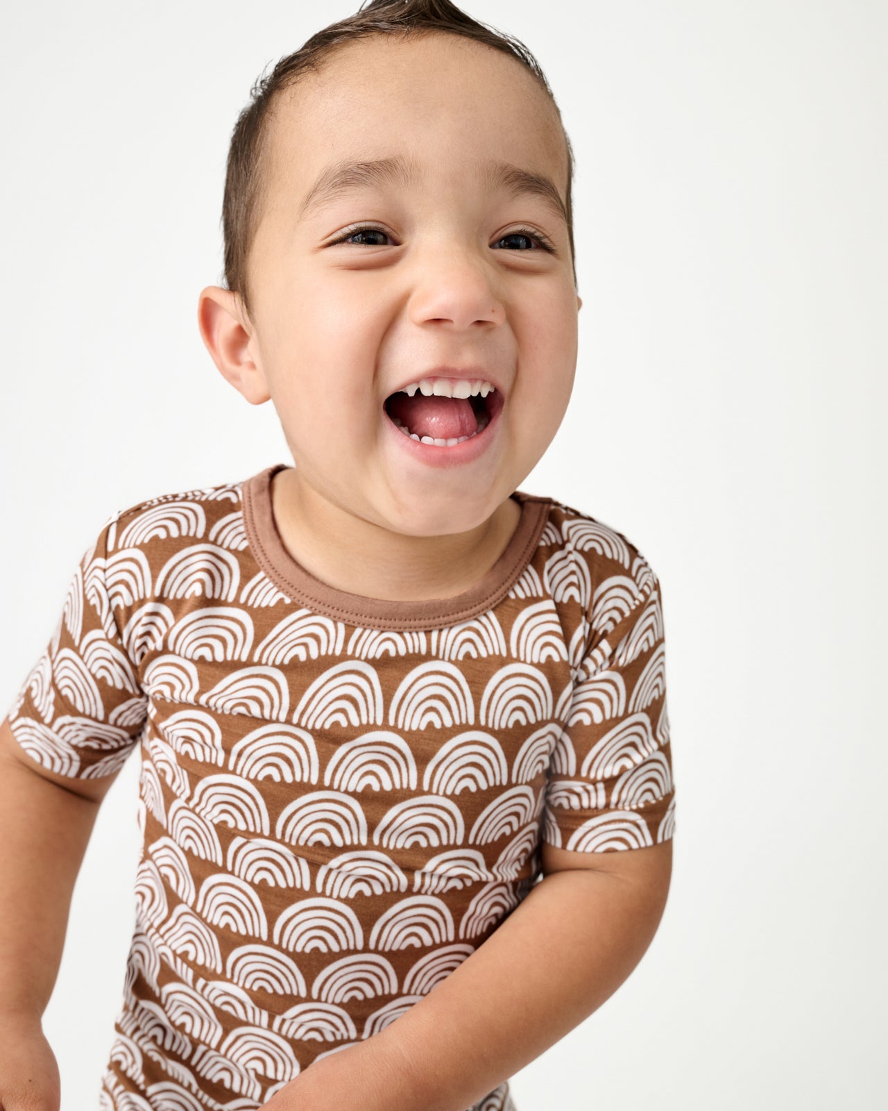 Close up of boy wearing the Rust Rainbows Two-Piece Short Sleeve & Shorts Pajama Set