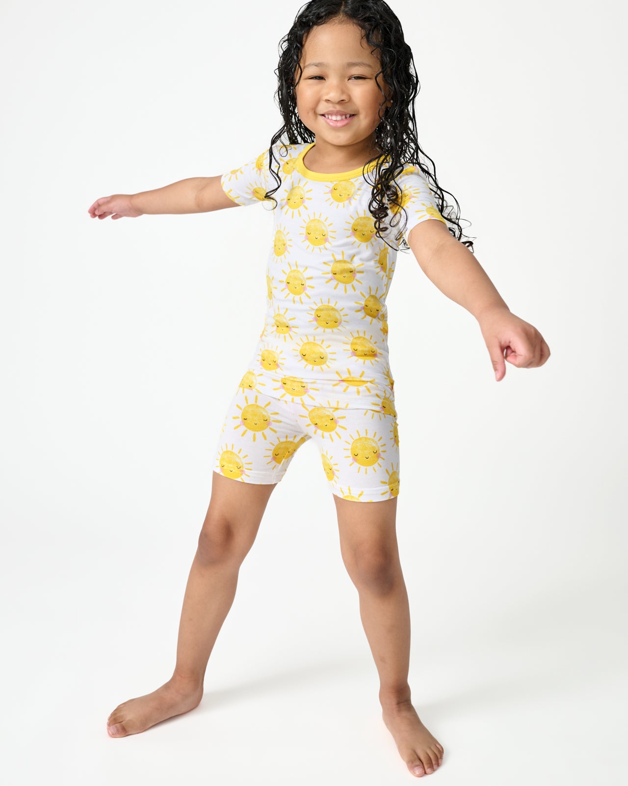 Standing child wearing the Sunshine Two-Piece Short Sleeve & Shorts Pajama Set