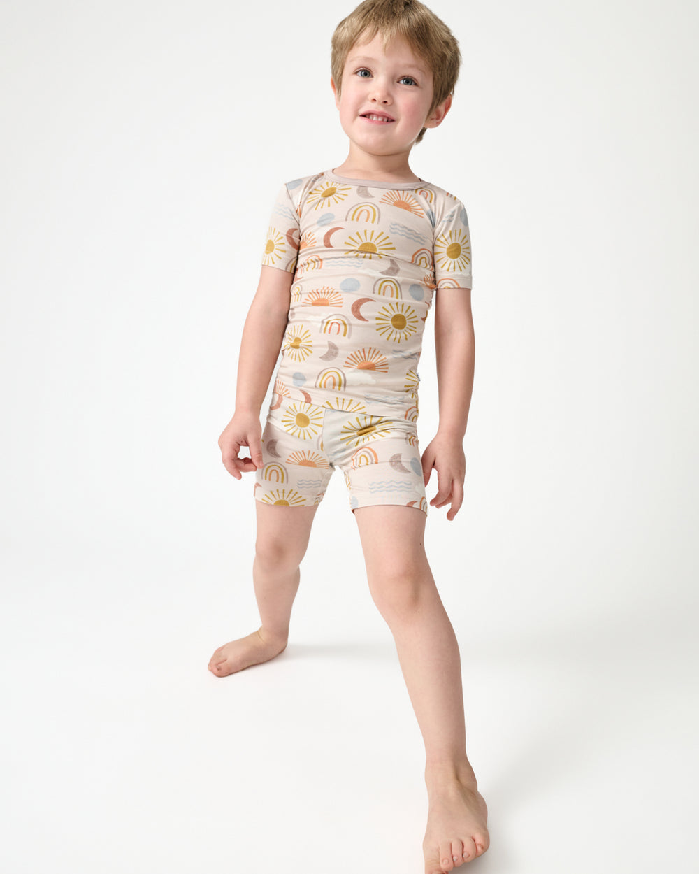 Standing boy wearing the Desert Sunrise Two-Piece Short Sleeve & Shorts Pajama Set