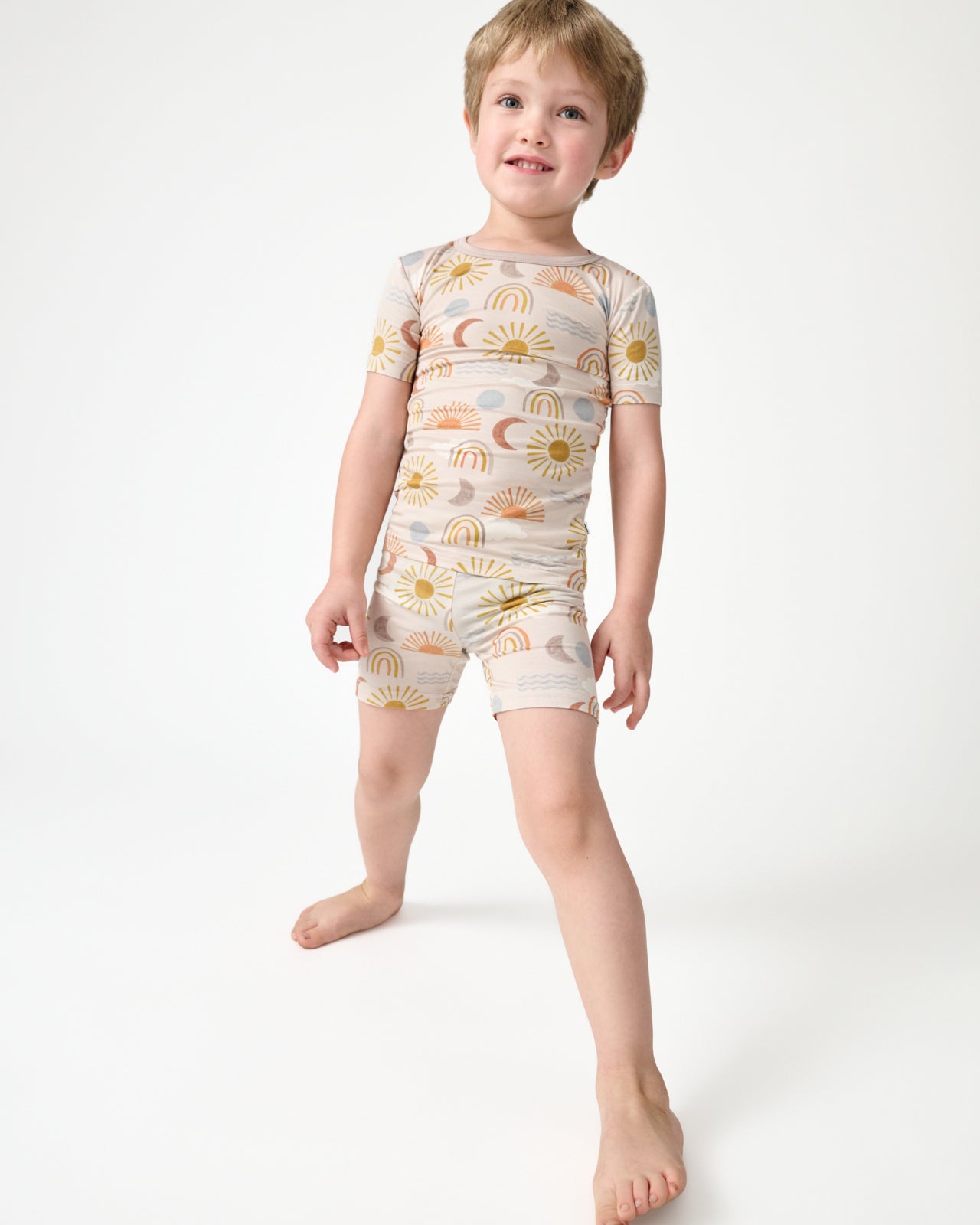 Standing boy wearing the Desert Sunrise Two-Piece Short Sleeve & Shorts Pajama Set
