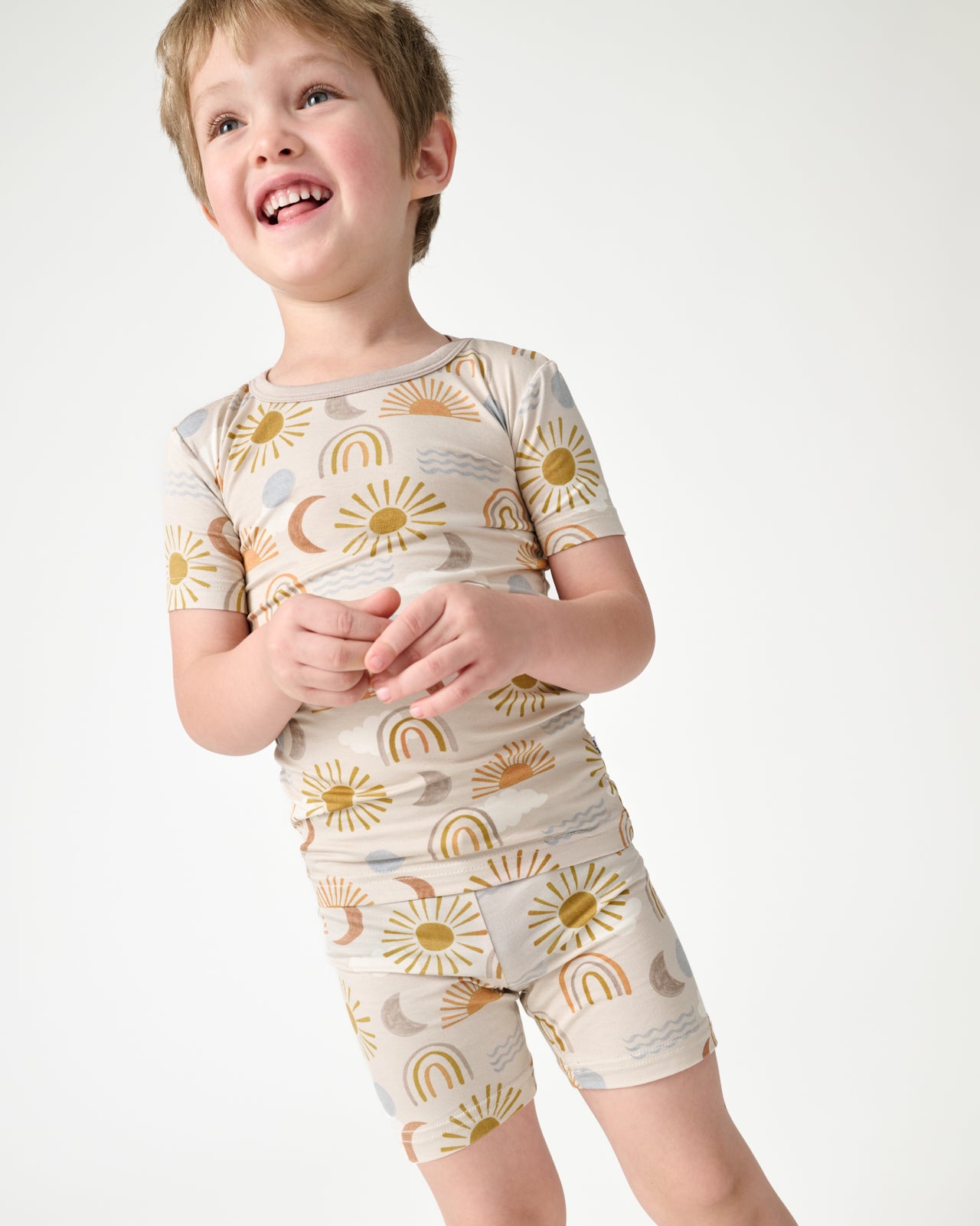 Close up of boy wearing the Desert Sunrise Two-Piece Short Sleeve & Shorts Pajama Set