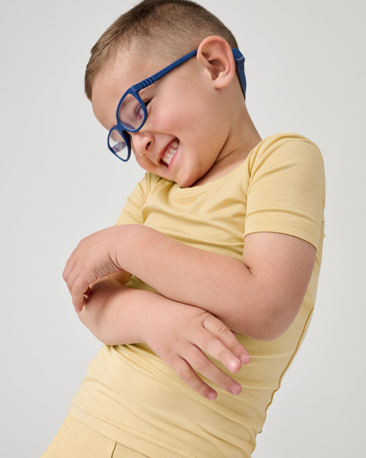 Smiling child wearing the Sunglow Two-Piece Short Sleeve & Shorts Pajama Set