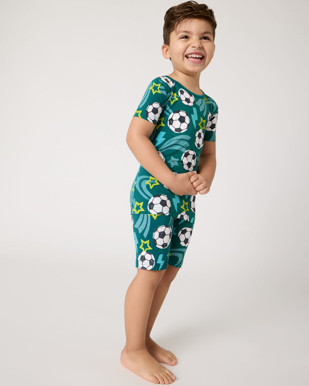Boy wearing the Soccer Stars Two-Piece Short Sleeve & Shorts Pajama Set