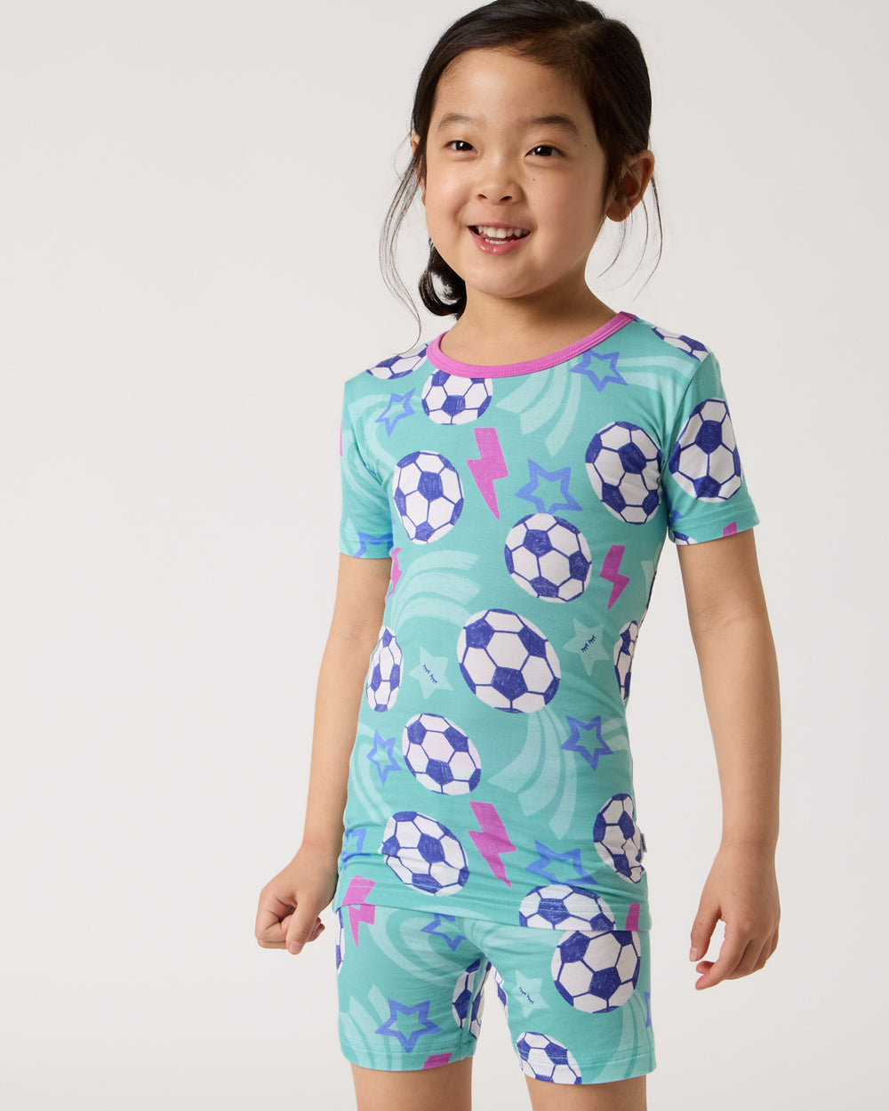 Close up of girl wearing the Aqua Soccer Stars Two-Piece Short Sleeve & Shorts Pajama Set