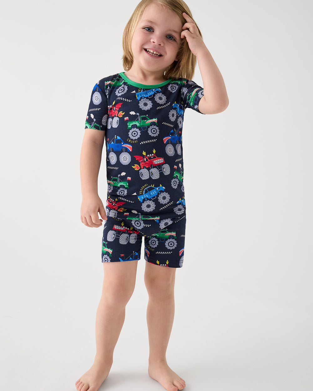 Boy wearing the Monster Truck Madness Two-Piece Short Sleeve & Shorts Pajama Set