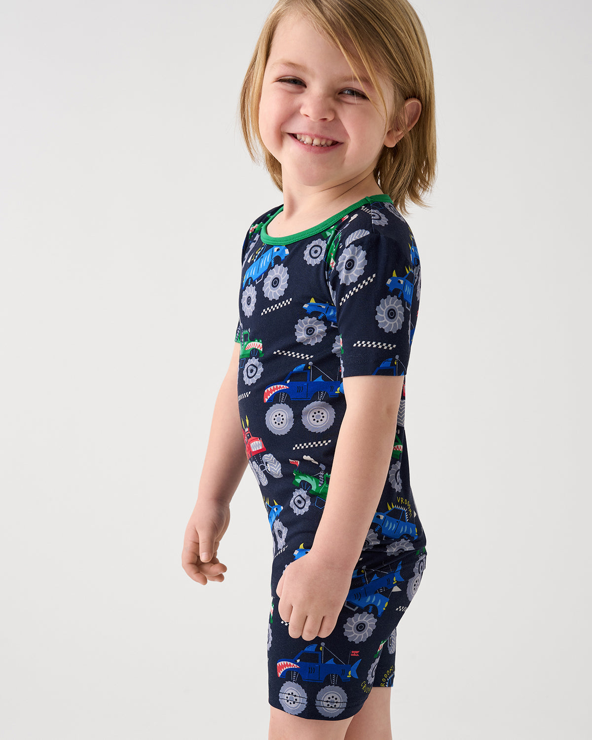 Close up of boy wearing the Monster Truck Madness Two-Piece Short Sleeve & Shorts Pajama Set
