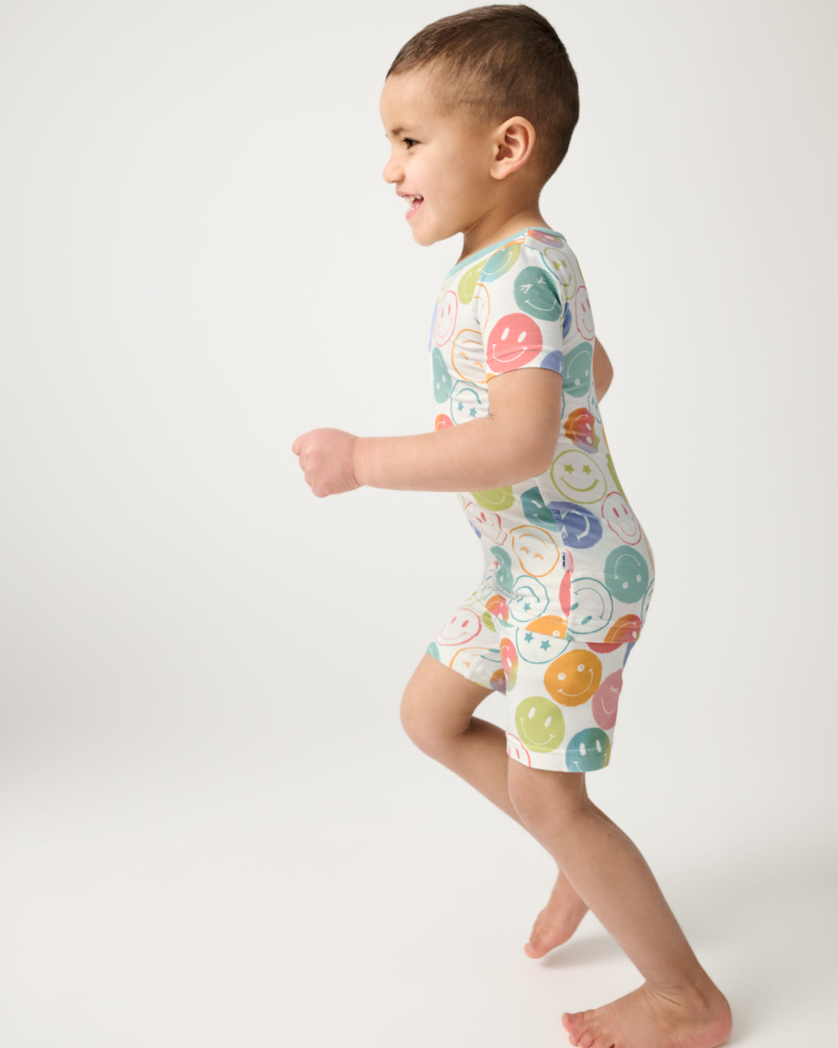 Running child wearing the Positive Vibes Two-Piece Short Sleeve & Shorts Pajama Set