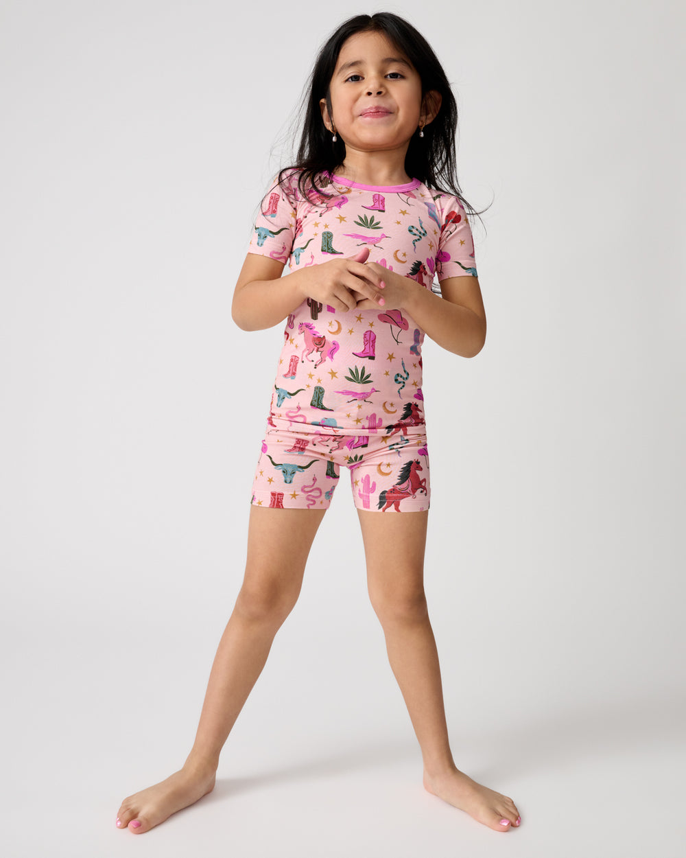 Standing girl wearing the Pink Rancher Roundup Two-Piece Short Sleeve & Shorts Pajama Set
