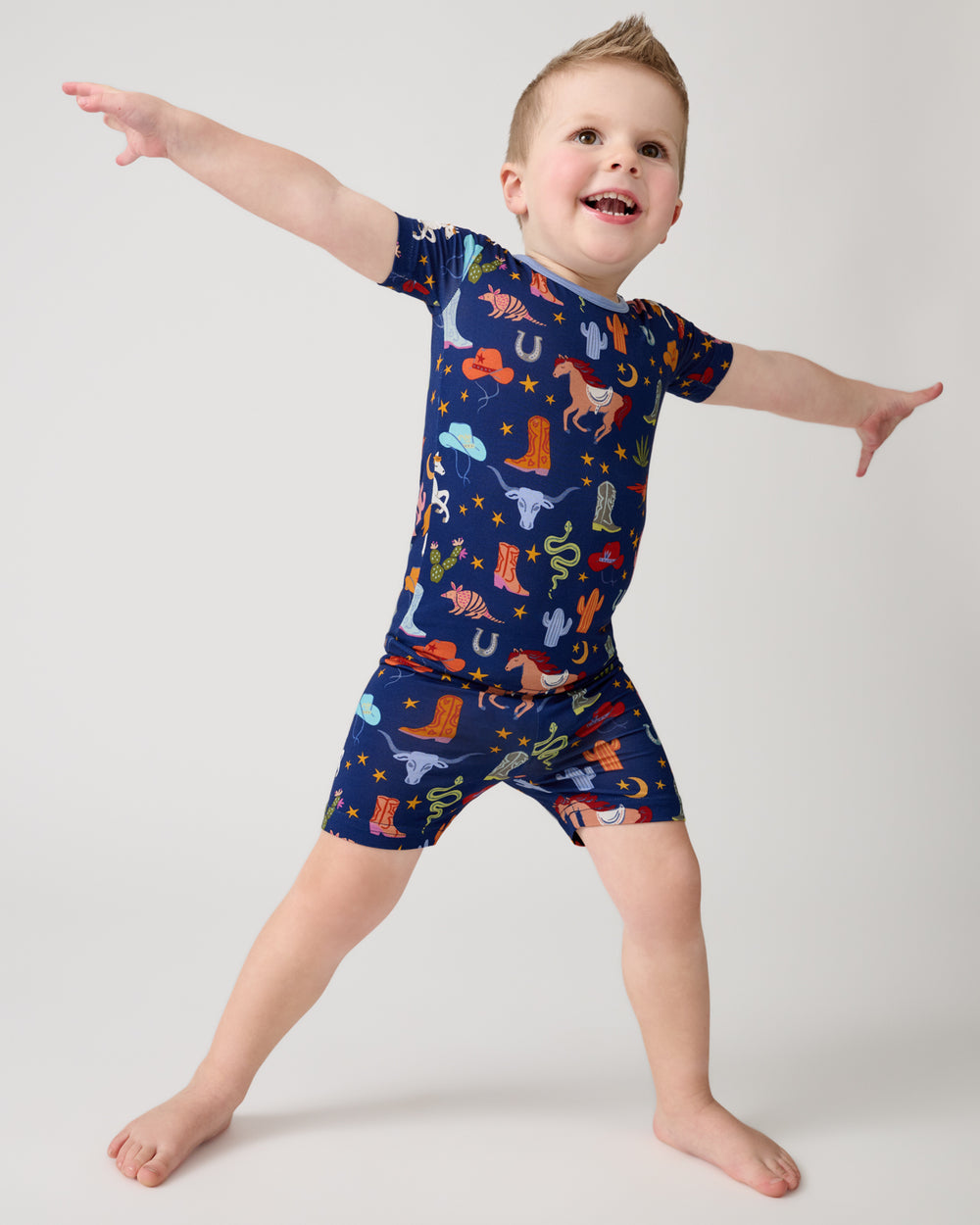 Posing boy wearing the Blue Rancher Roundup Two-Piece Short Sleeve & Shorts Pajama Set