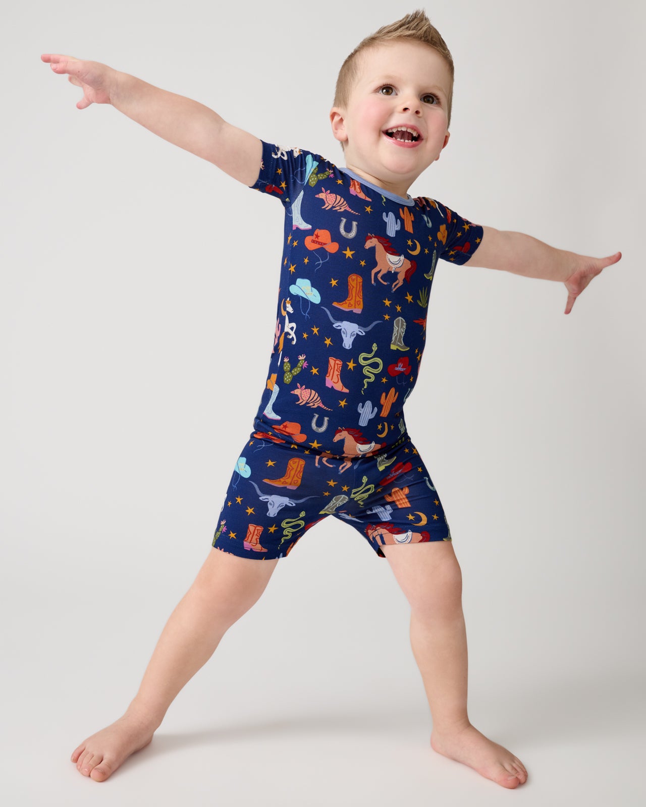Posing boy wearing the Blue Rancher Roundup Two-Piece Short Sleeve & Shorts Pajama Set