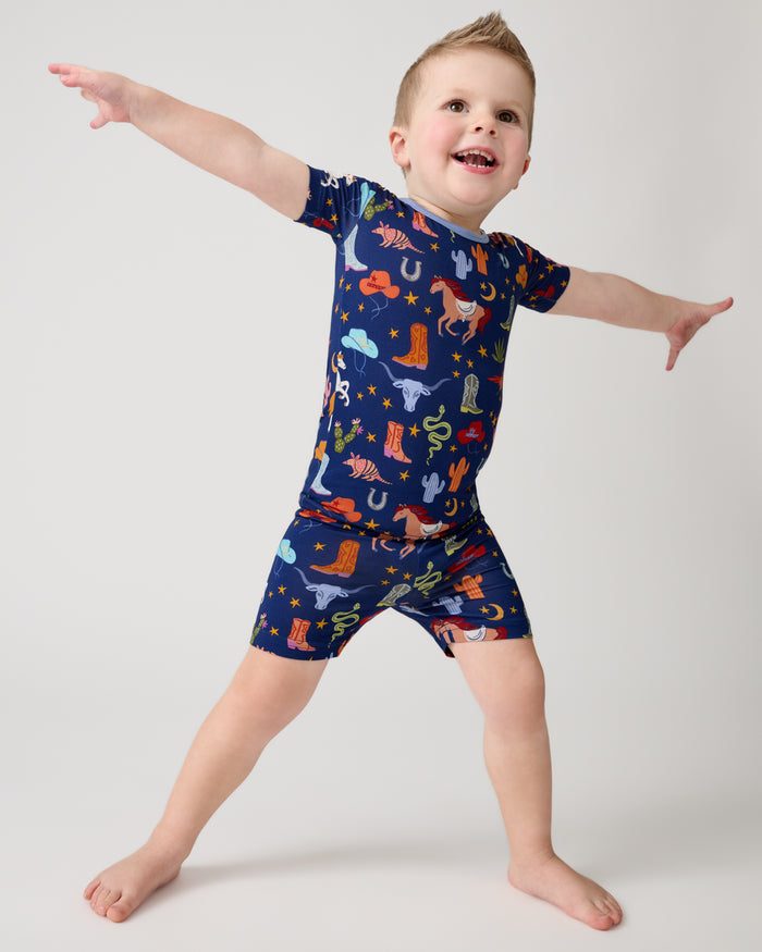 Posing boy wearing the Blue Rancher Roundup Two-Piece Short Sleeve & Shorts Pajama Set