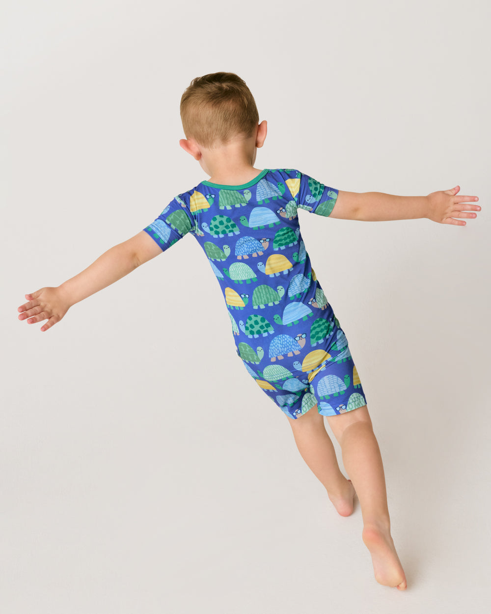 Child in motion wearing the Shell Parade Two-Piece Short Sleeve & Shorts Pajama Set