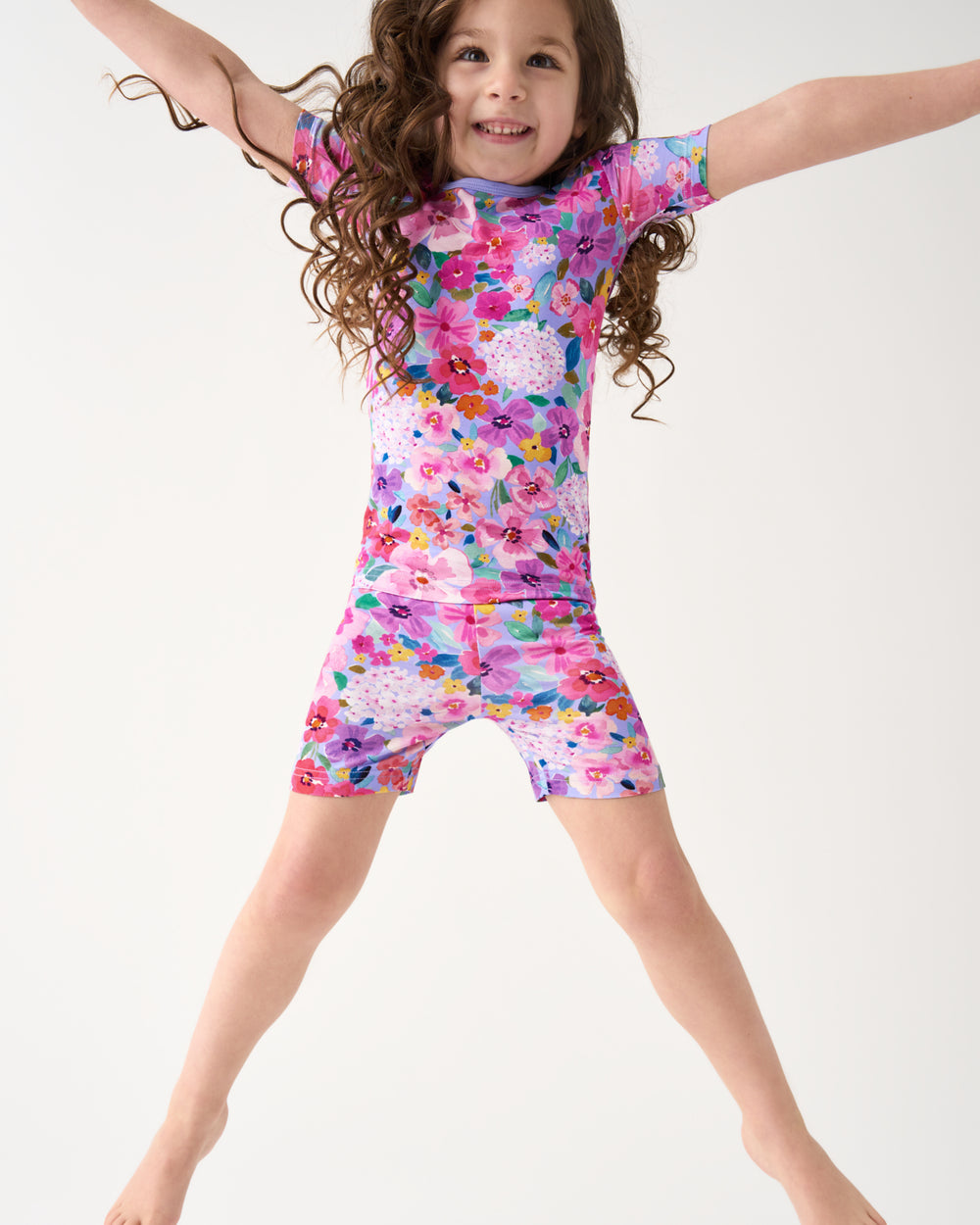 Jumping girl wearing the Sweet Sprigs Two-Piece Short Sleeve & Shorts Pajama Set