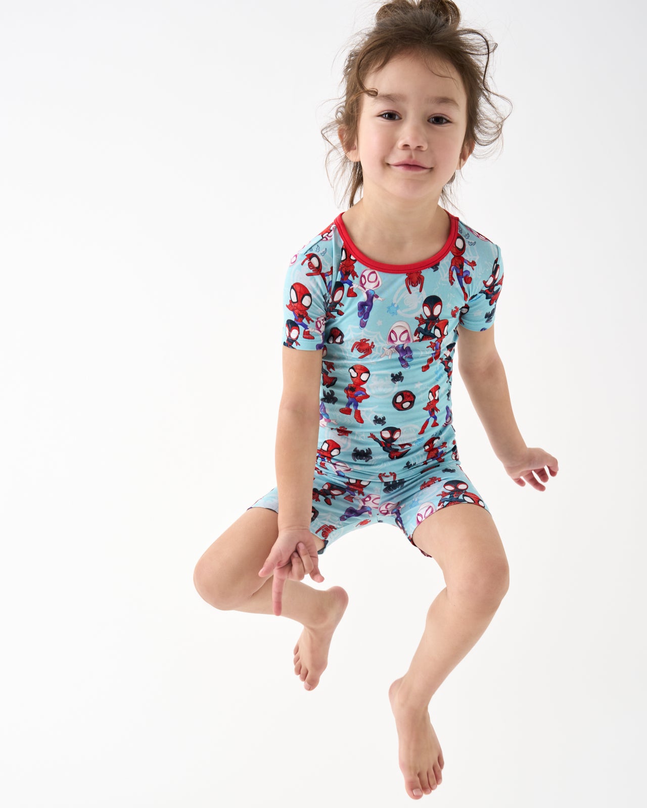 Jumping girl wearing the Spidey & Friends Tiny Webs Two-Piece Short Sleeve & Shorts Pajama Set
