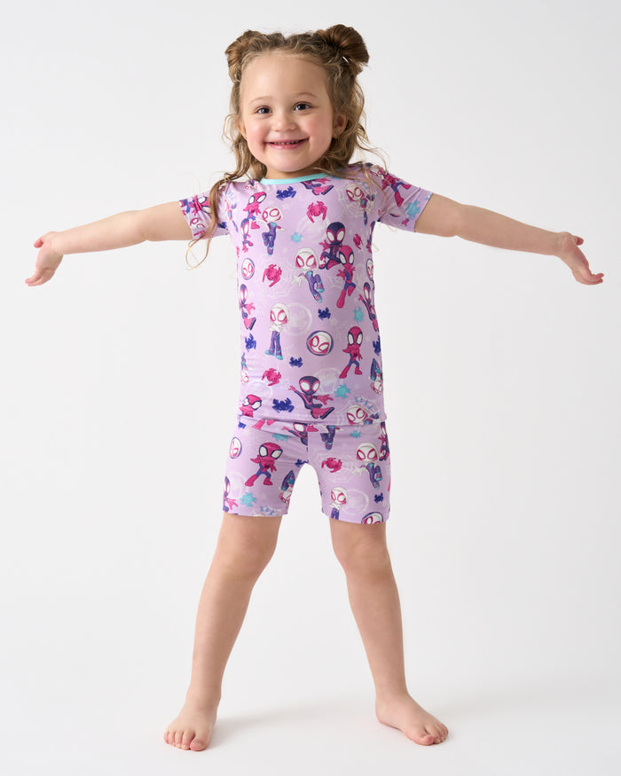 Posing girl wearing the Spidey & Friends Tiny Webs Two-Piece Short Sleeve & Shorts Pajama Set