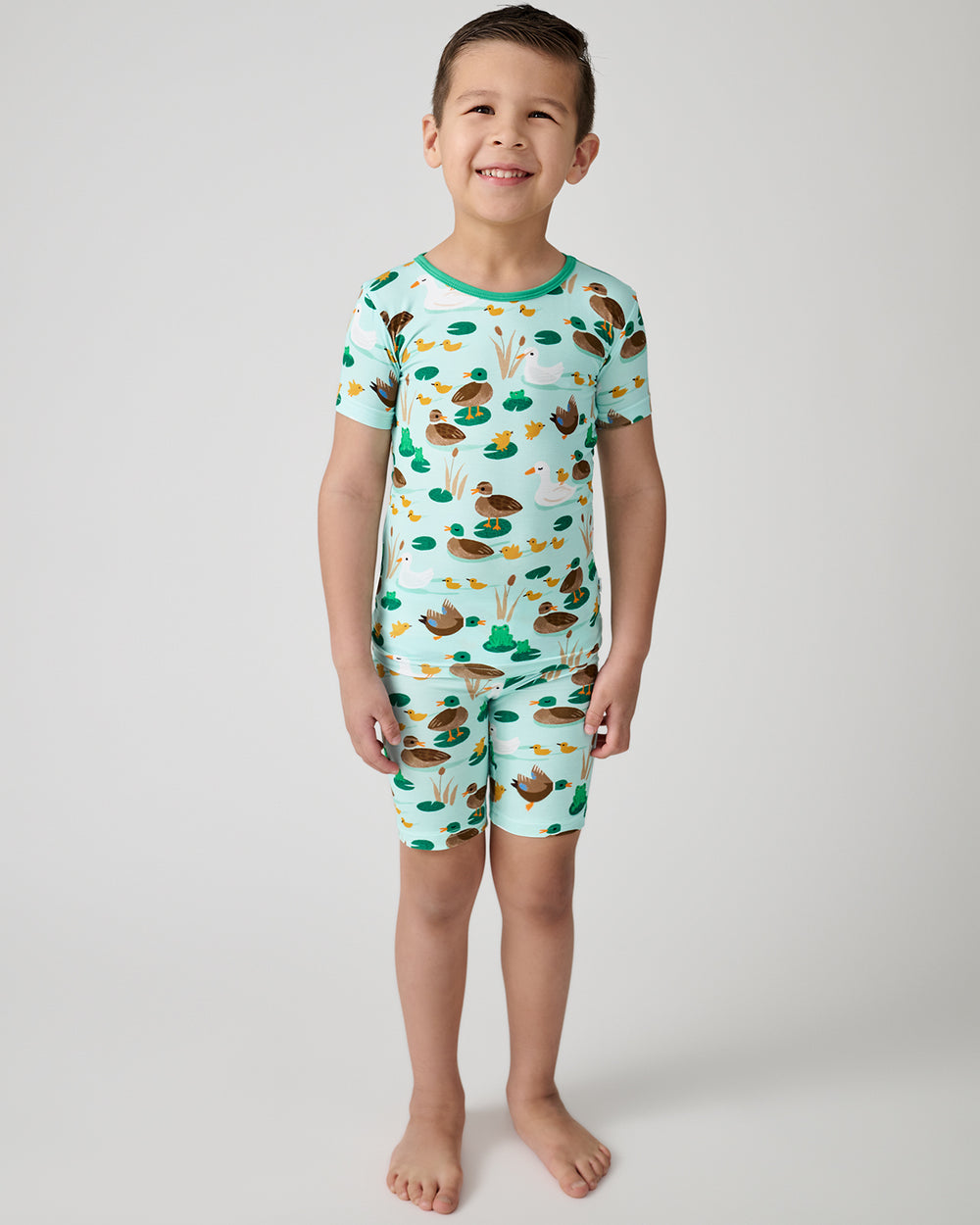 Standing boy wearing the Puddle Jumpers Two-Piece Short Sleeve & Shorts Pajama Set