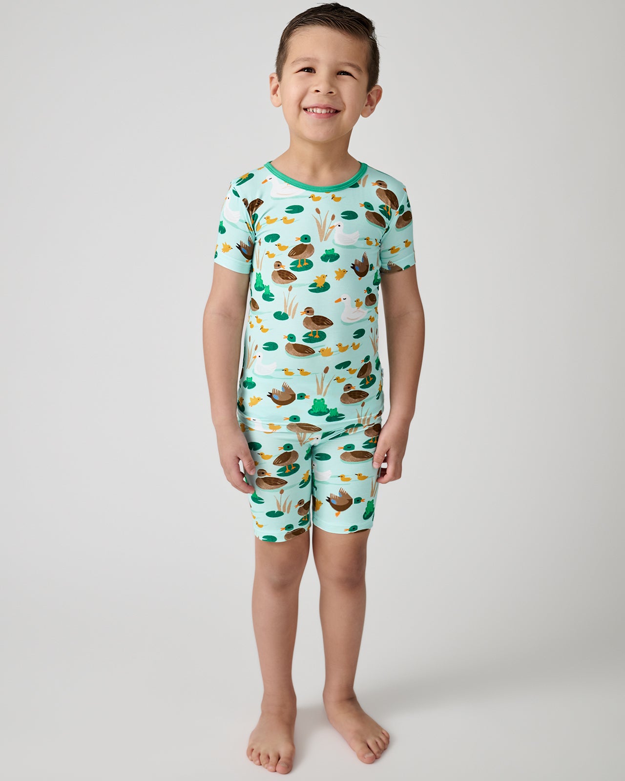 Standing boy wearing the Puddle Jumpers Two-Piece Short Sleeve & Shorts Pajama Set