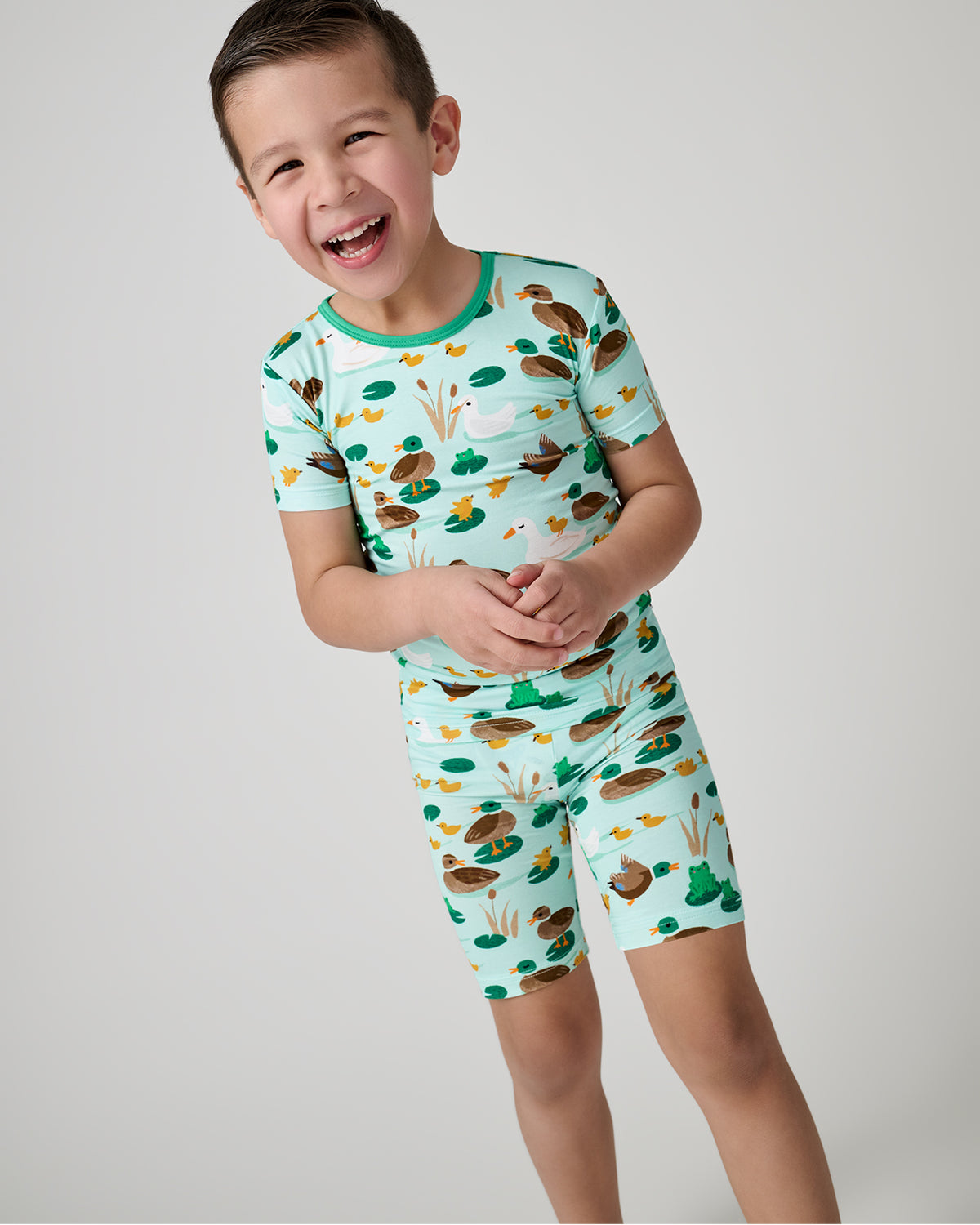 Smiling child wearing the Puddle Jumpers Two-Piece Short Sleeve & Shorts Pajama Set