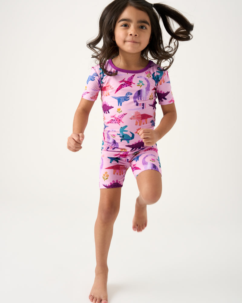 Jumping child wearing the Pink Roar & Explore Two-Piece Short Sleeve & Shorts Pajama Set