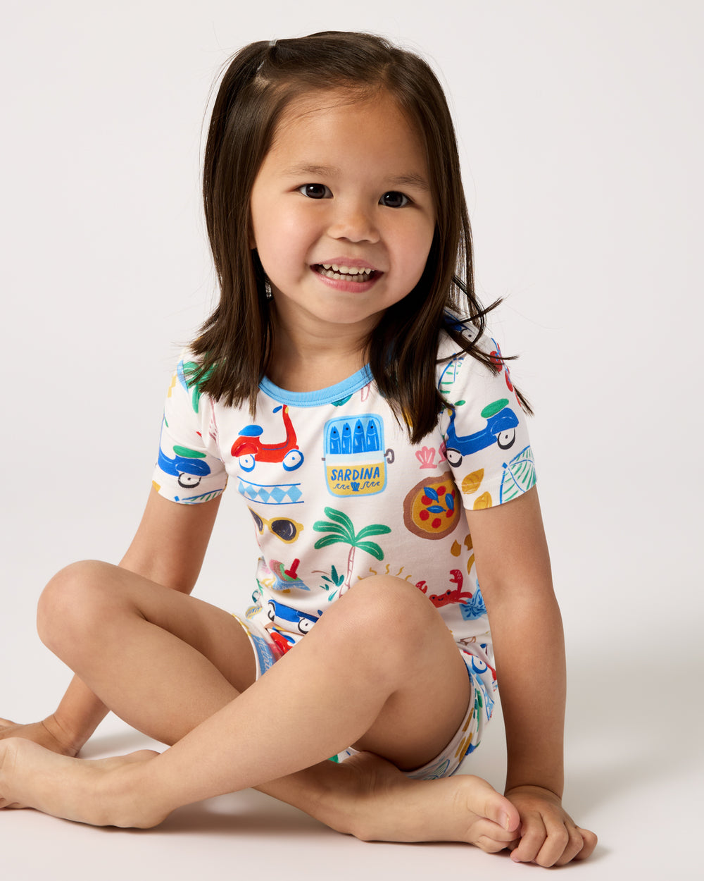 Sitting girl wearing the Ciao Bella Two-Piece Short Sleeve & Shorts Pajama Set