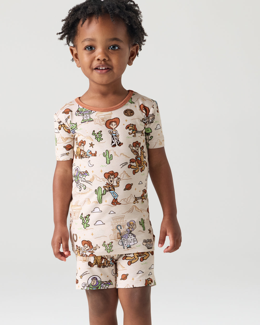 Close up of child wearing the Disney & Pixar Woody's Wild West Two-Piece Short Sleeve & Shorts Pajama Set
