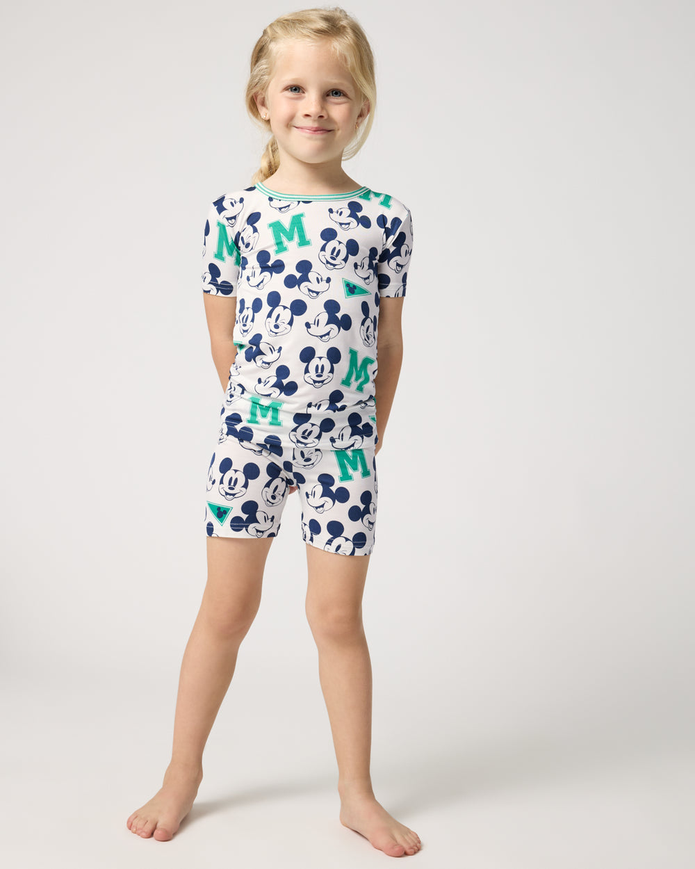 Standing girl wearing the Disney Varsity Mickey Mouse Two-Piece Short Sleeve & Shorts Pajama Set