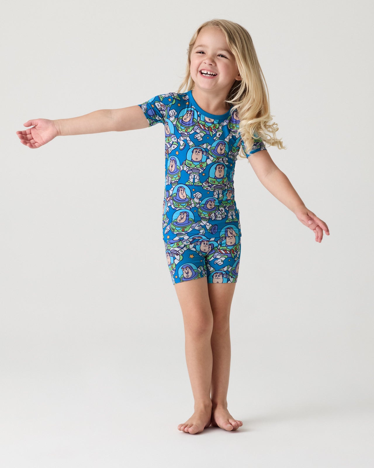 Standing girl wearing the Disney & Pixar Buzz's Cosmic Crew Two-Piece Short Sleeve & Shorts Pajama Set