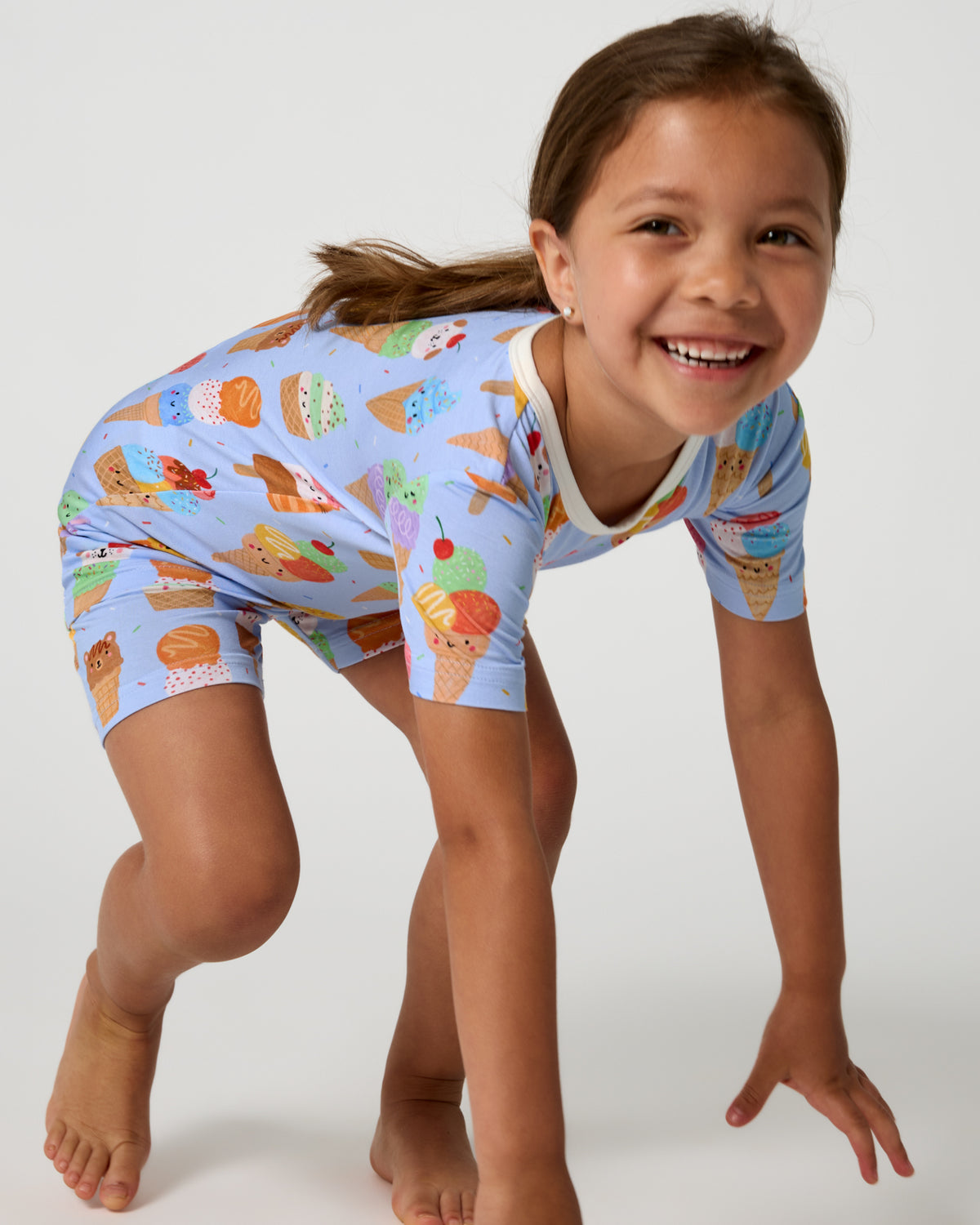 Child in motion wearing the Scoop Squad Two-Piece Short Sleeve & Shorts Pajama Set