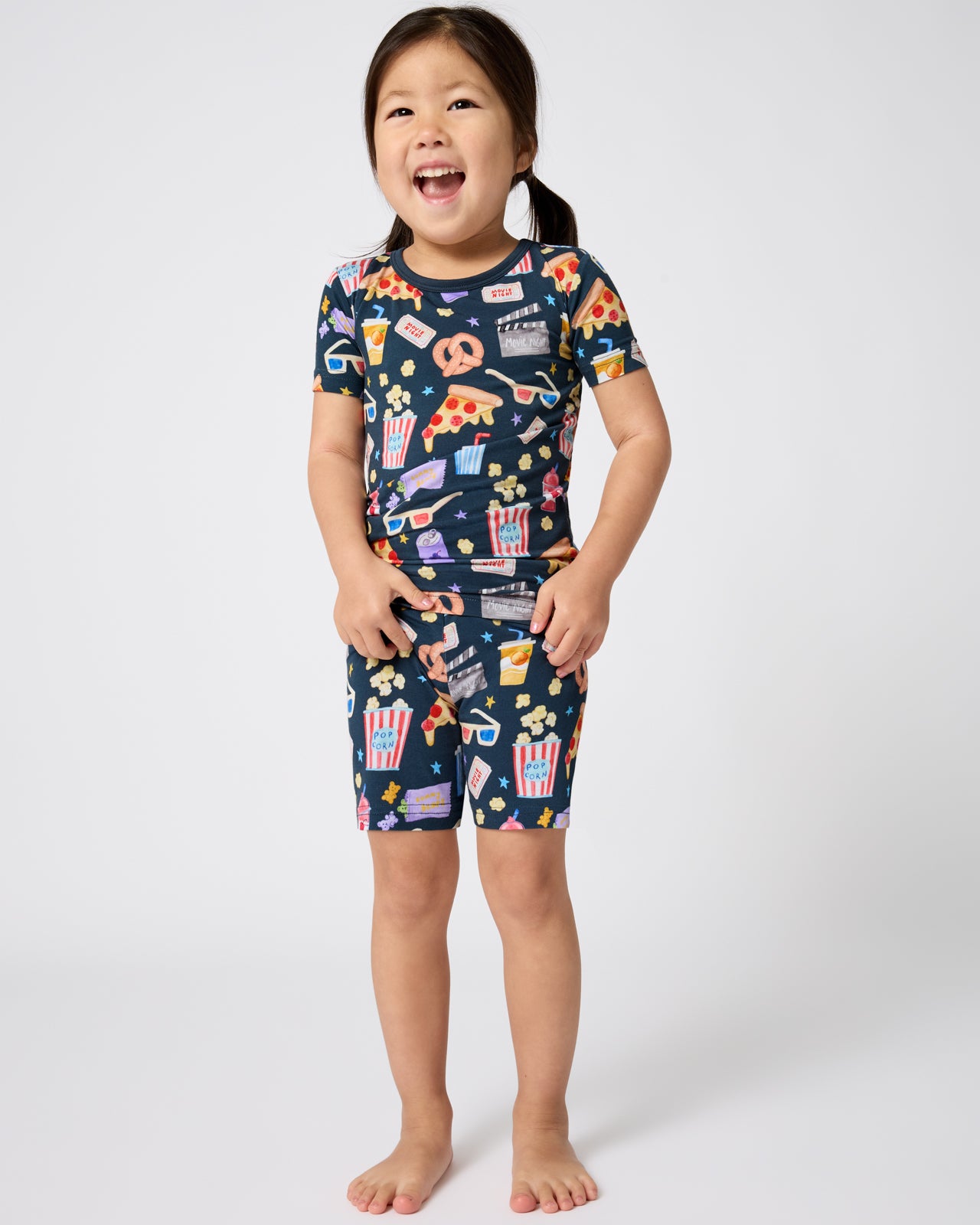 Standing girl wearing the Movie Marathon Two-Piece Short Sleeve & Shorts Pajama Set