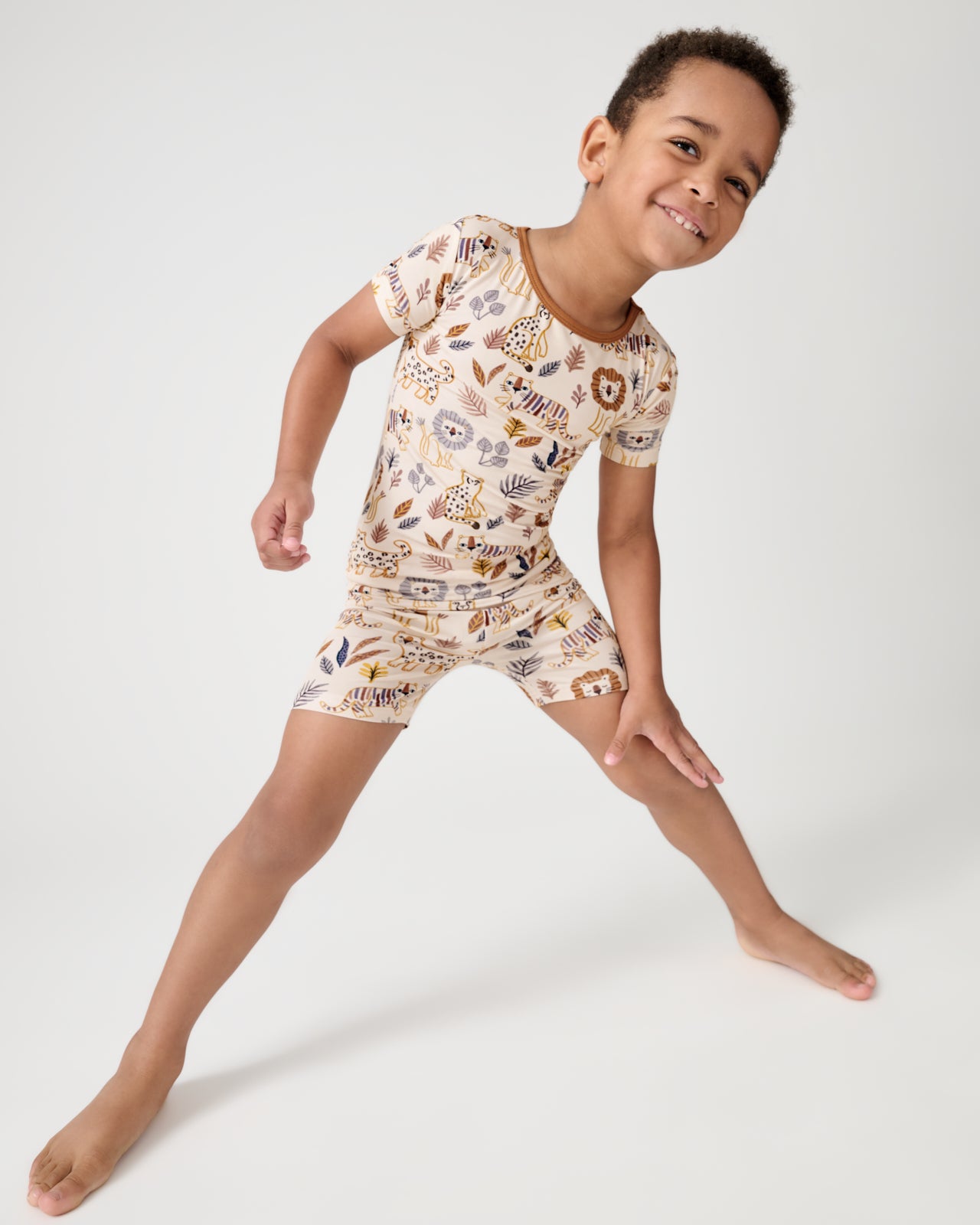 Standing boy wearing the Savanna Friends Two-Piece Short Sleeve & Shorts Pajama Set