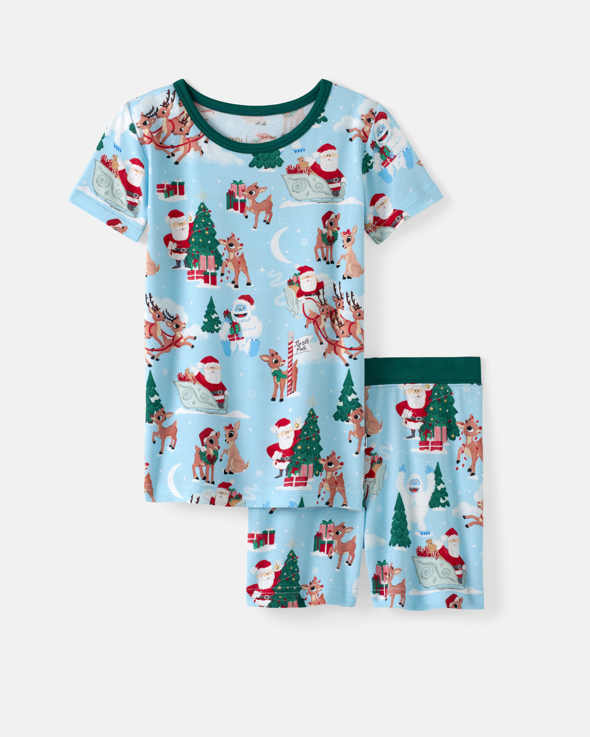 A two-piece children's pajama set featuring a light blue long-sleeve top and matching shorts with an all-over Christmas print of Santa Claus, reindeer, Christmas trees, and gifts. The set has dark green trim on the top's neckline and the shorts' waistband, shown against a plain light gray background.