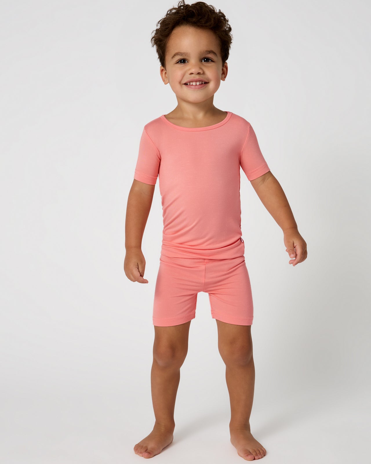 Standing child wearing the Sweet Papaya Two-Piece Short Sleeve & Shorts Pajama Set