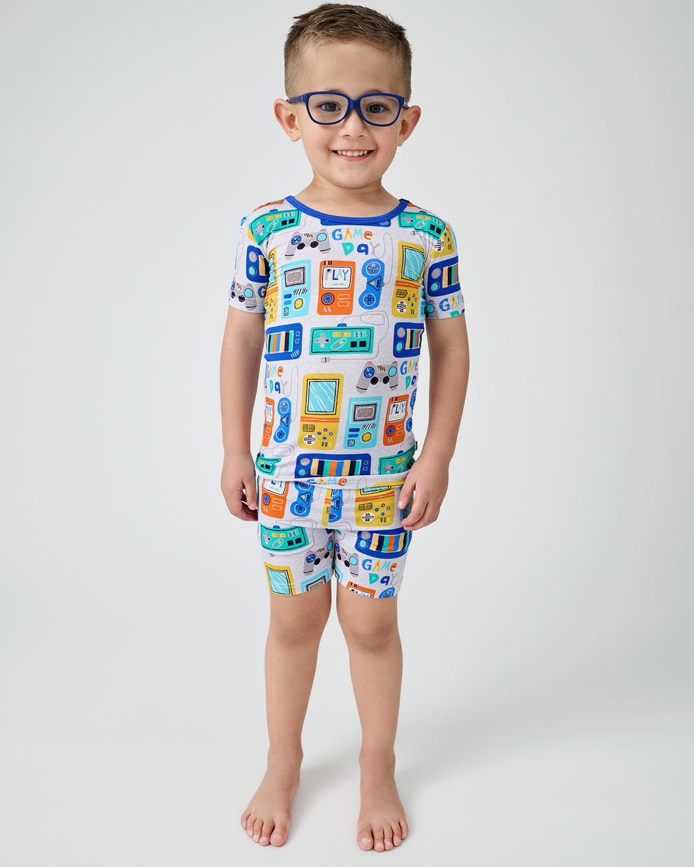 Standing boy wearing the Game On Two-Piece Short Sleeve & Shorts Pajama Set