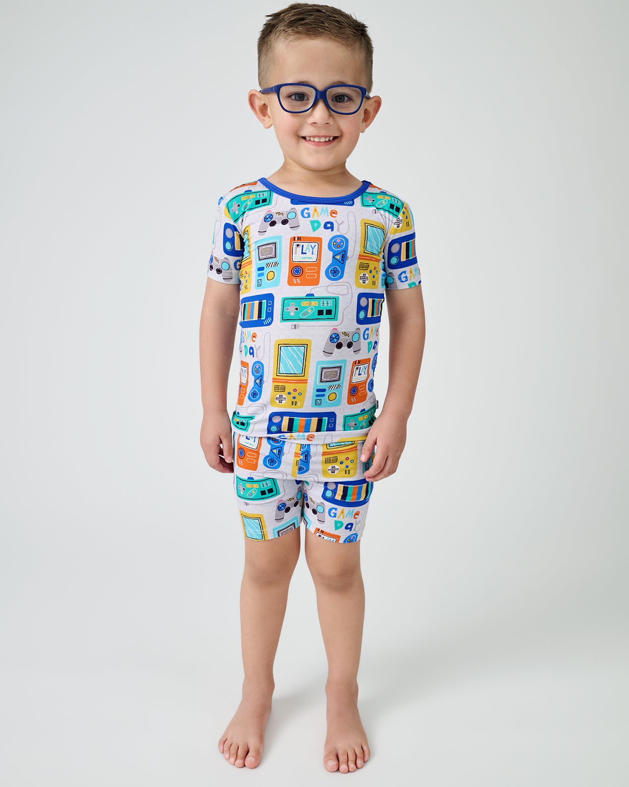 Standing boy wearing the Game On Two-Piece Short Sleeve & Shorts Pajama Set