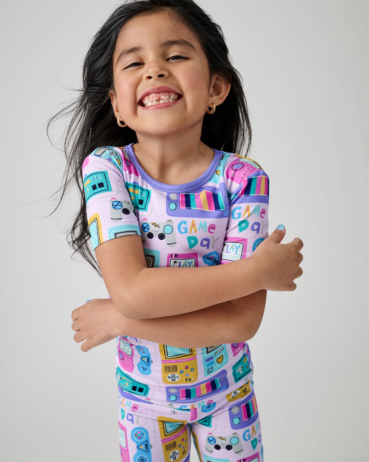 Smiling child wearing the Purple Game On Two-Piece Short Sleeve & Shorts Pajama Set