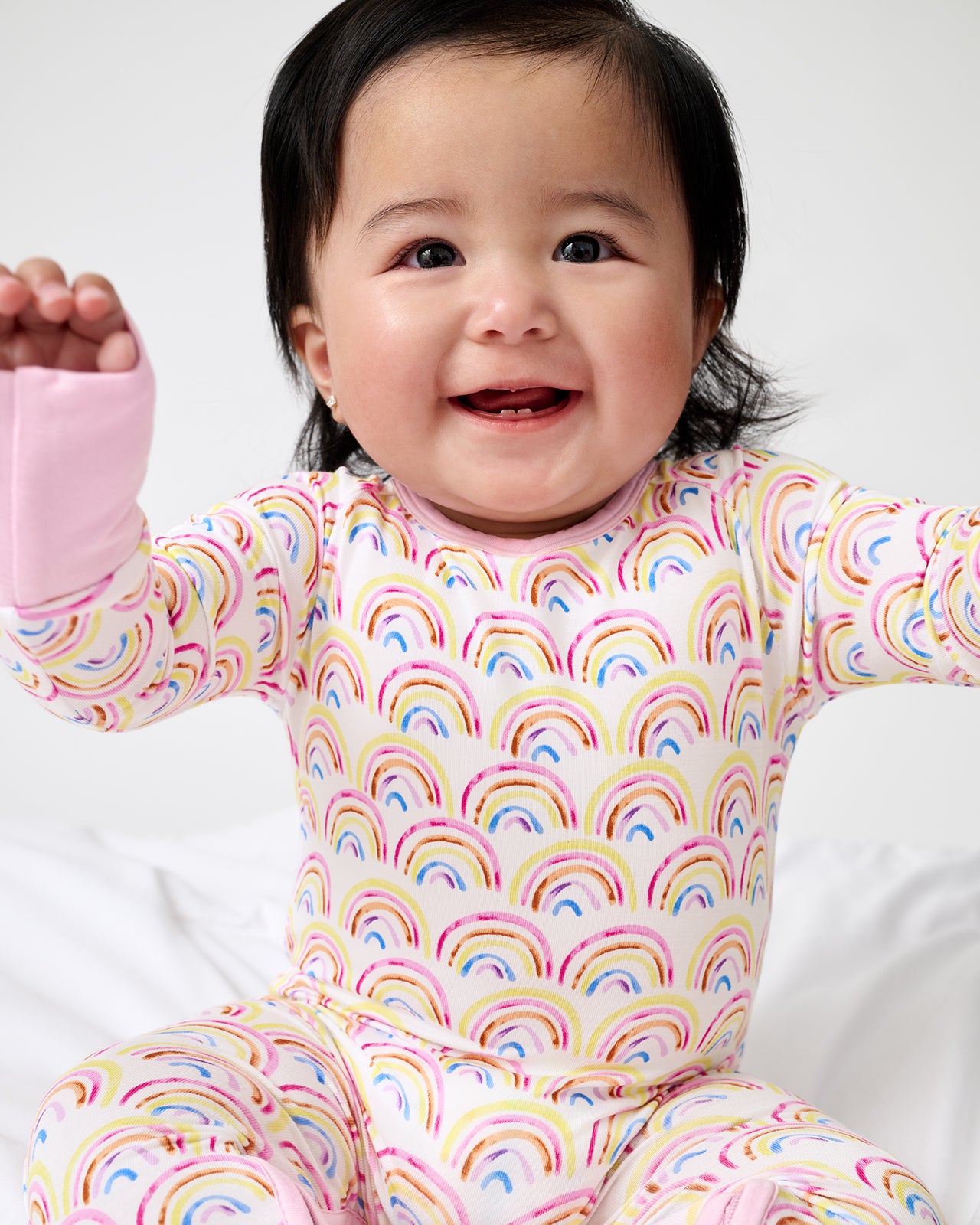 Close up of newborn wearing the Pastel Rainbows Crescent Zippy