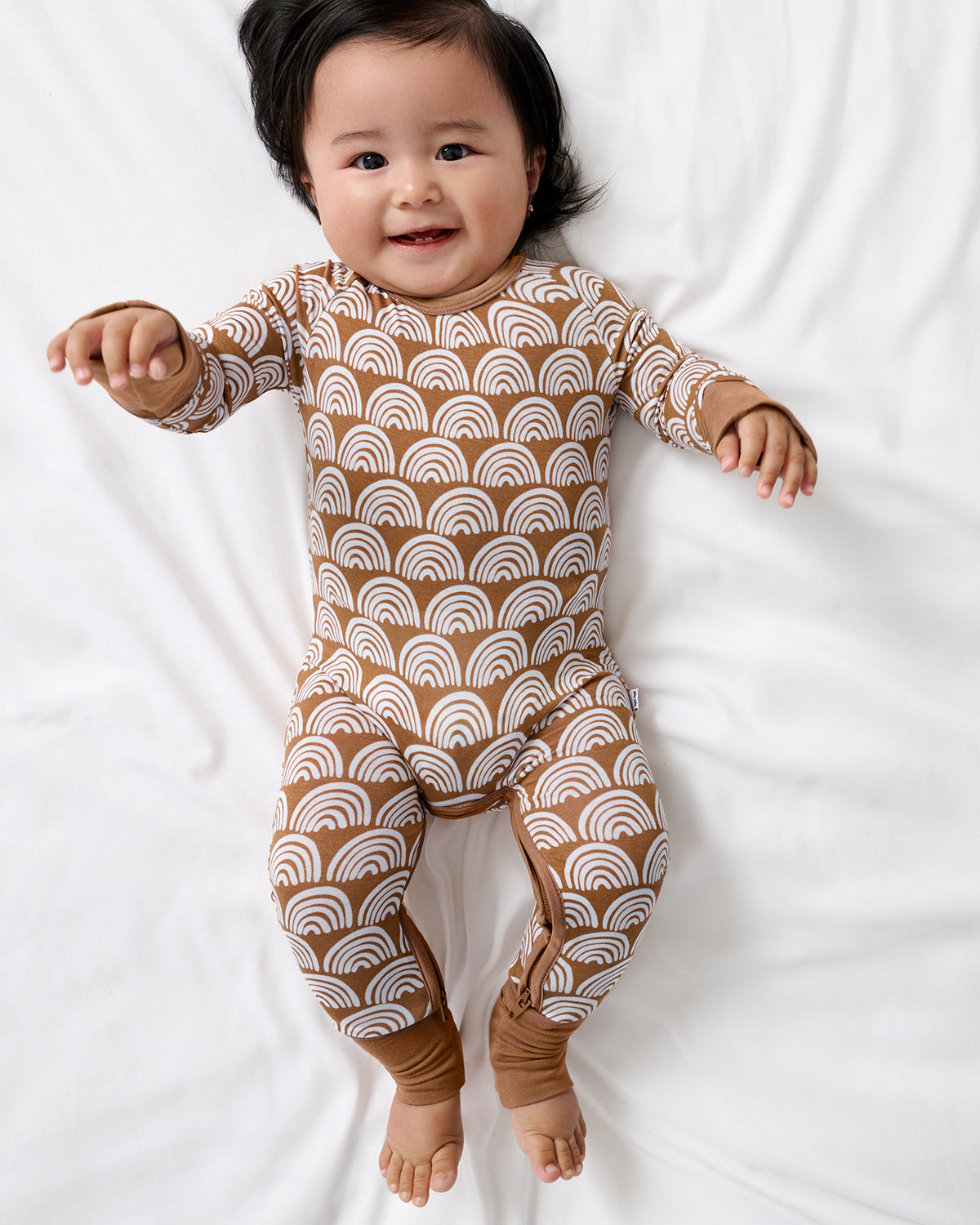 Aerial view of newborn wearing the Rust Rainbows Crescent Zippy