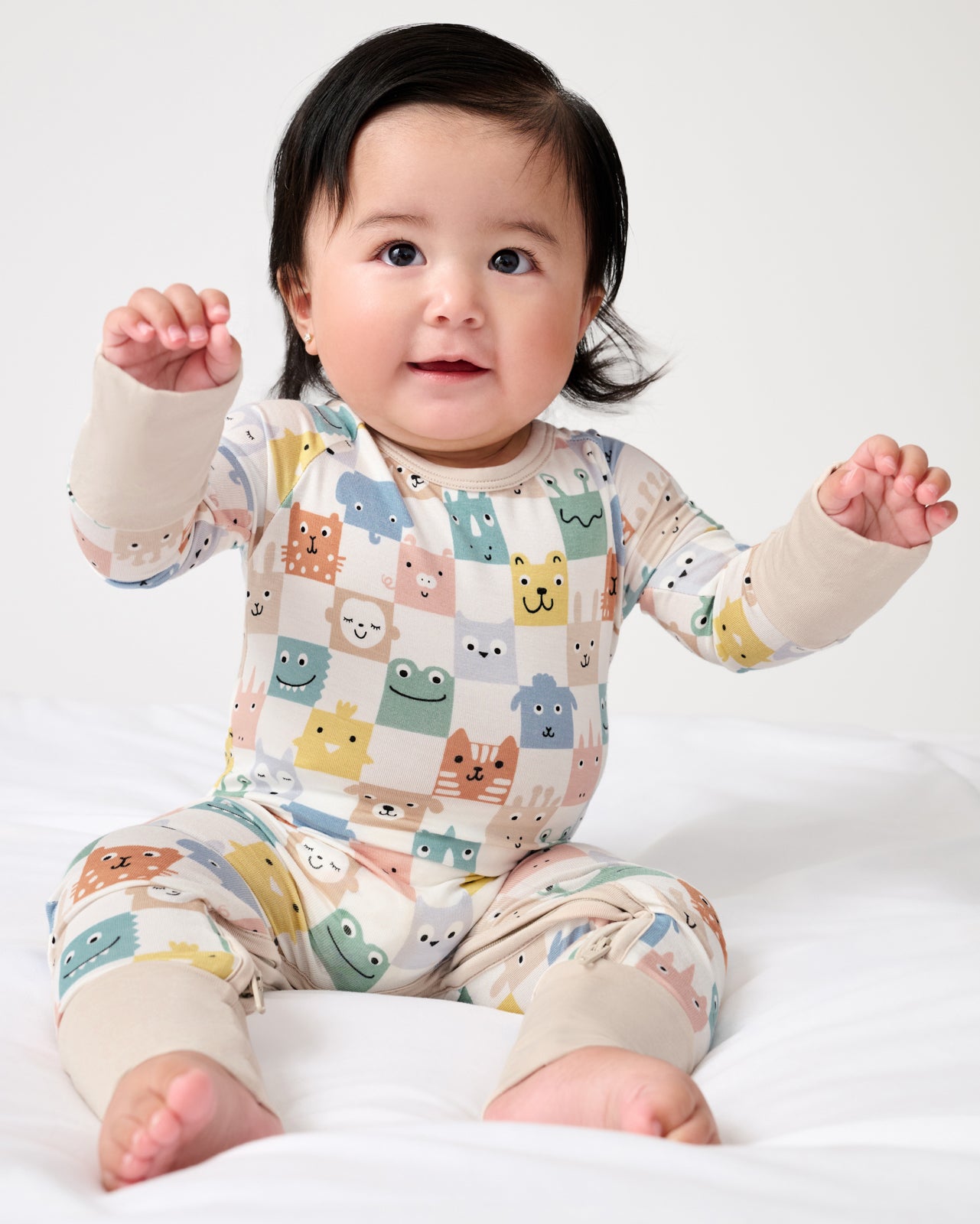 Sitting baby wearing the Check Mates Crescent Zippy