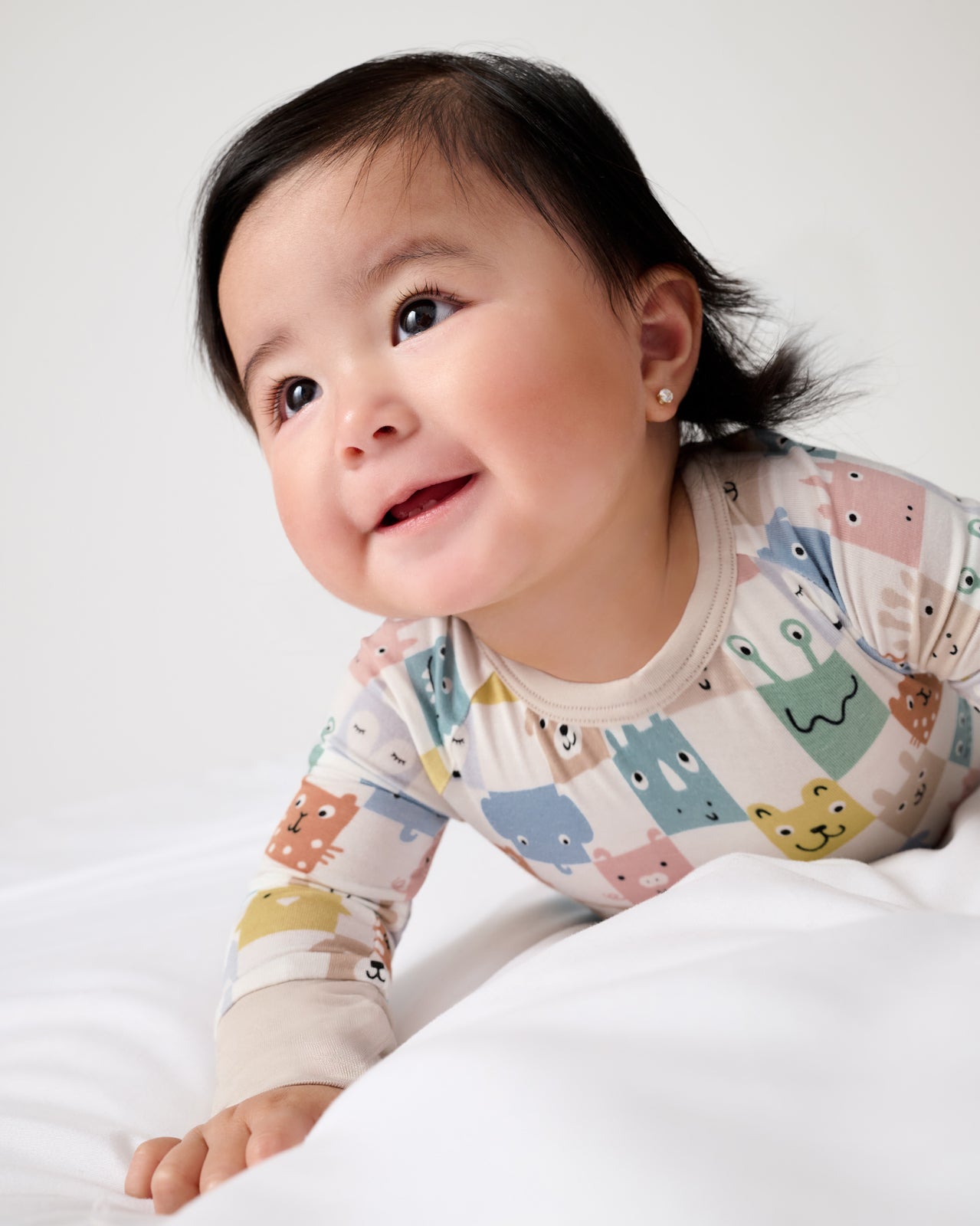 Baby on her tummy wearing the Check Mates Crescent Zippy