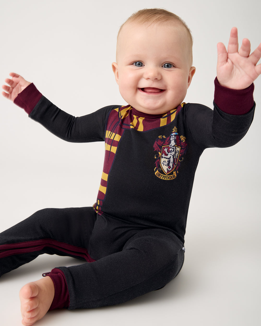 Sitting baby wearing the Harry Potter™ Gryffindor Crescent Zippy PJ