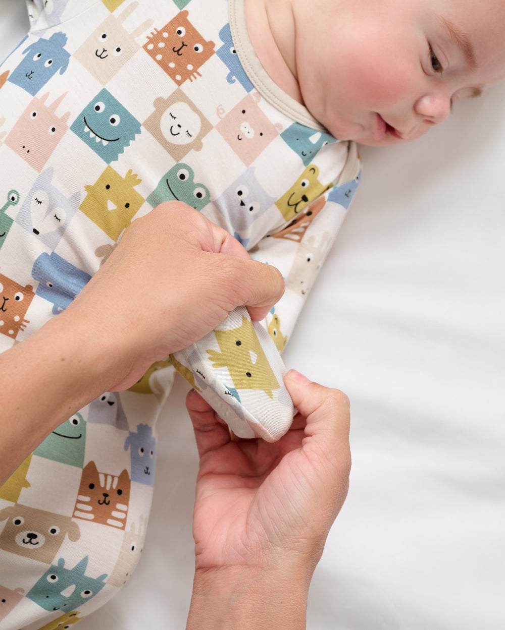 Adult demonstrating the hand foldover feature on the Check Mates Infant Gown