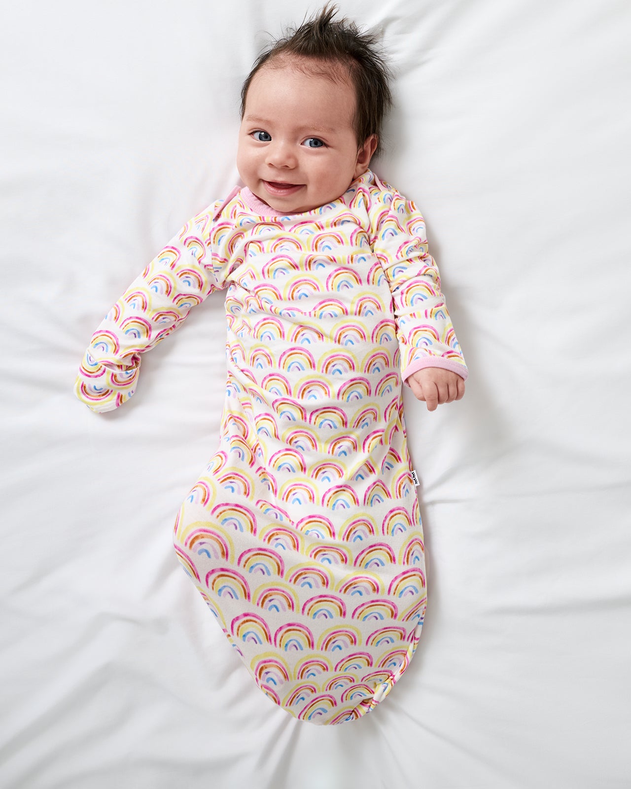 Aerial view of newborn wearing the Pastel Rainbows Infant Gown