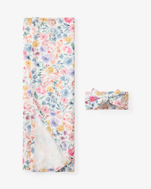 Flat lay of the Tiny Blooms Swaddle & Luxe Bow Headband Set