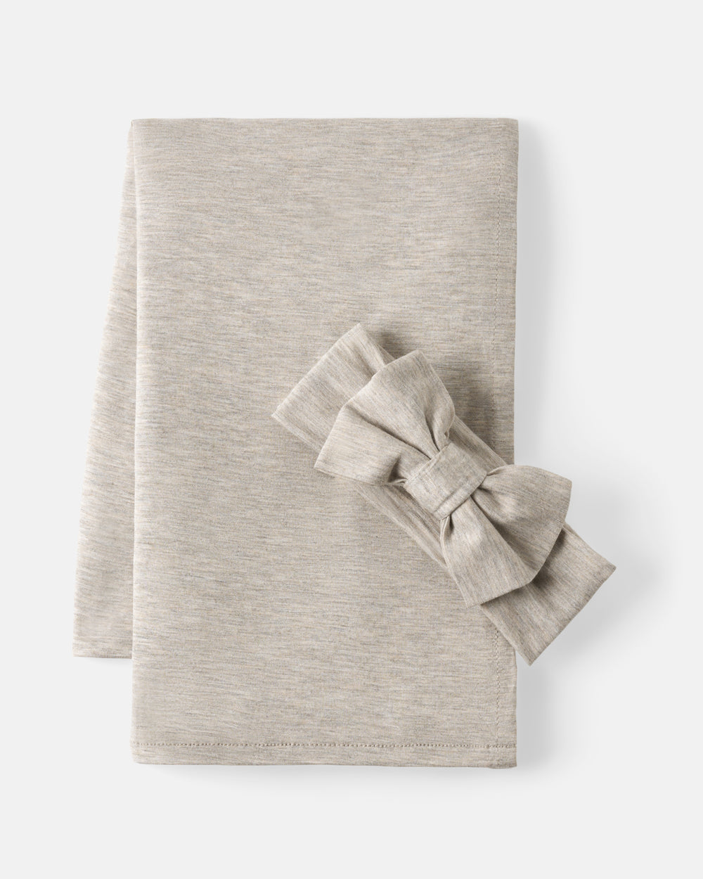 A folded light beige heathered fabric item with a matching fabric bow placed on top, photographed on a clean white background.
