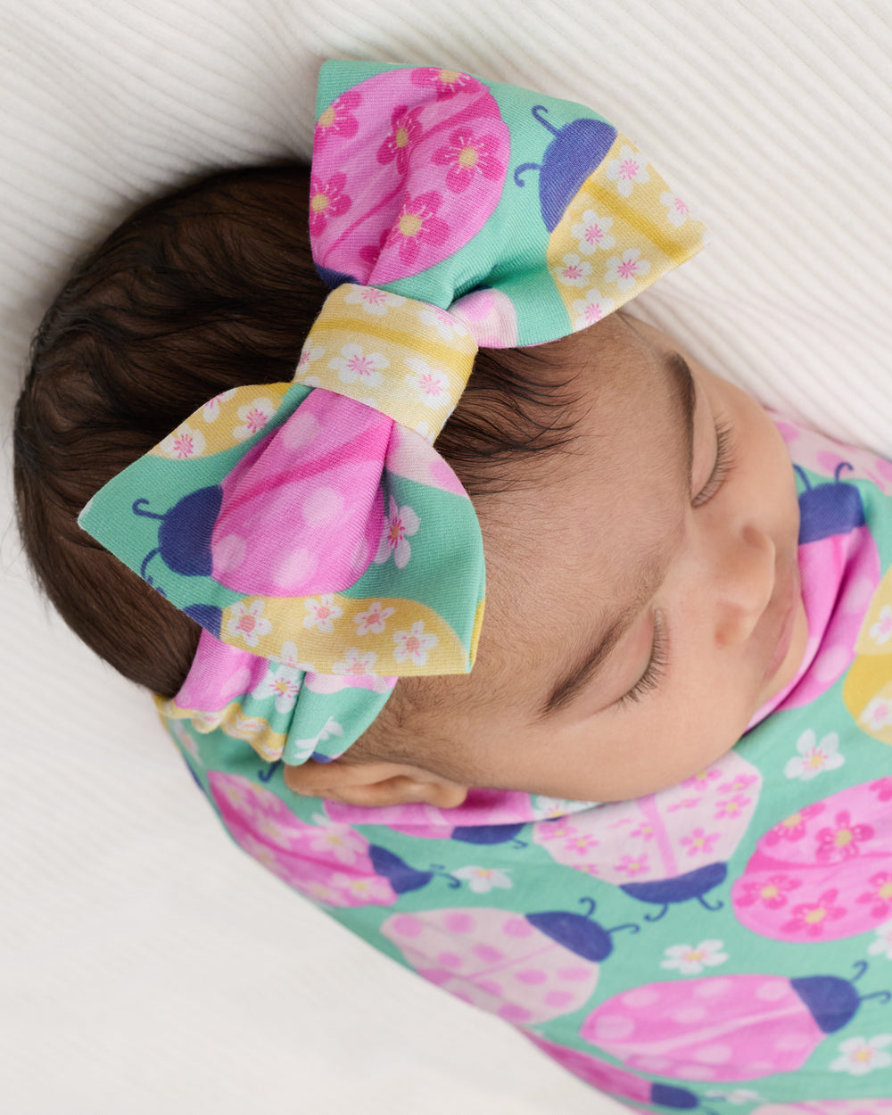 Close up of newborn wearing the Ladybug Meadow Luxe Bow Headband
