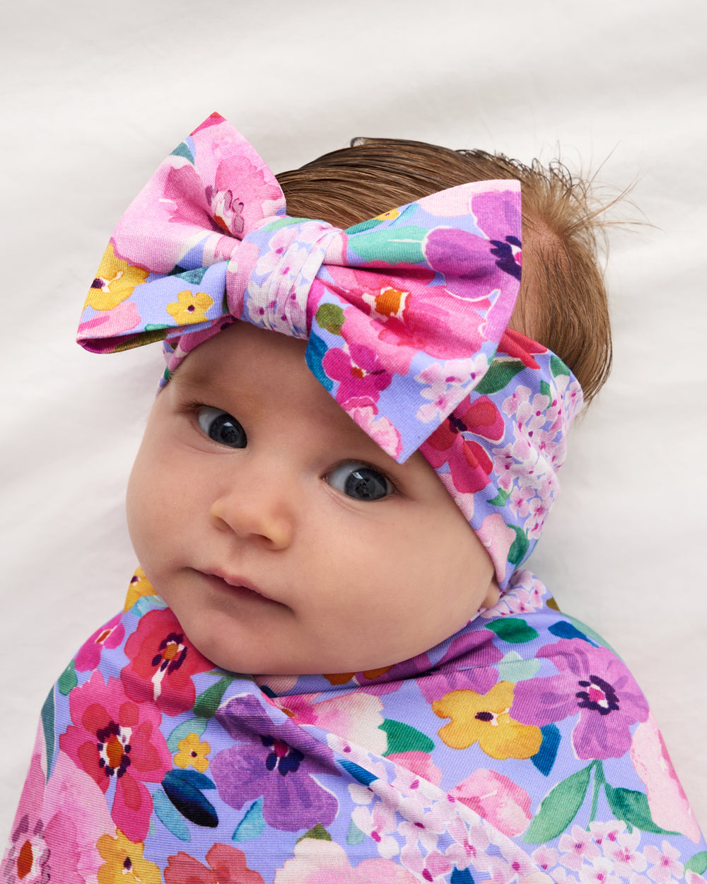 Close up of baby wearing the Sweet Sprigs Swaddle & Luxe Bow Headband Set
