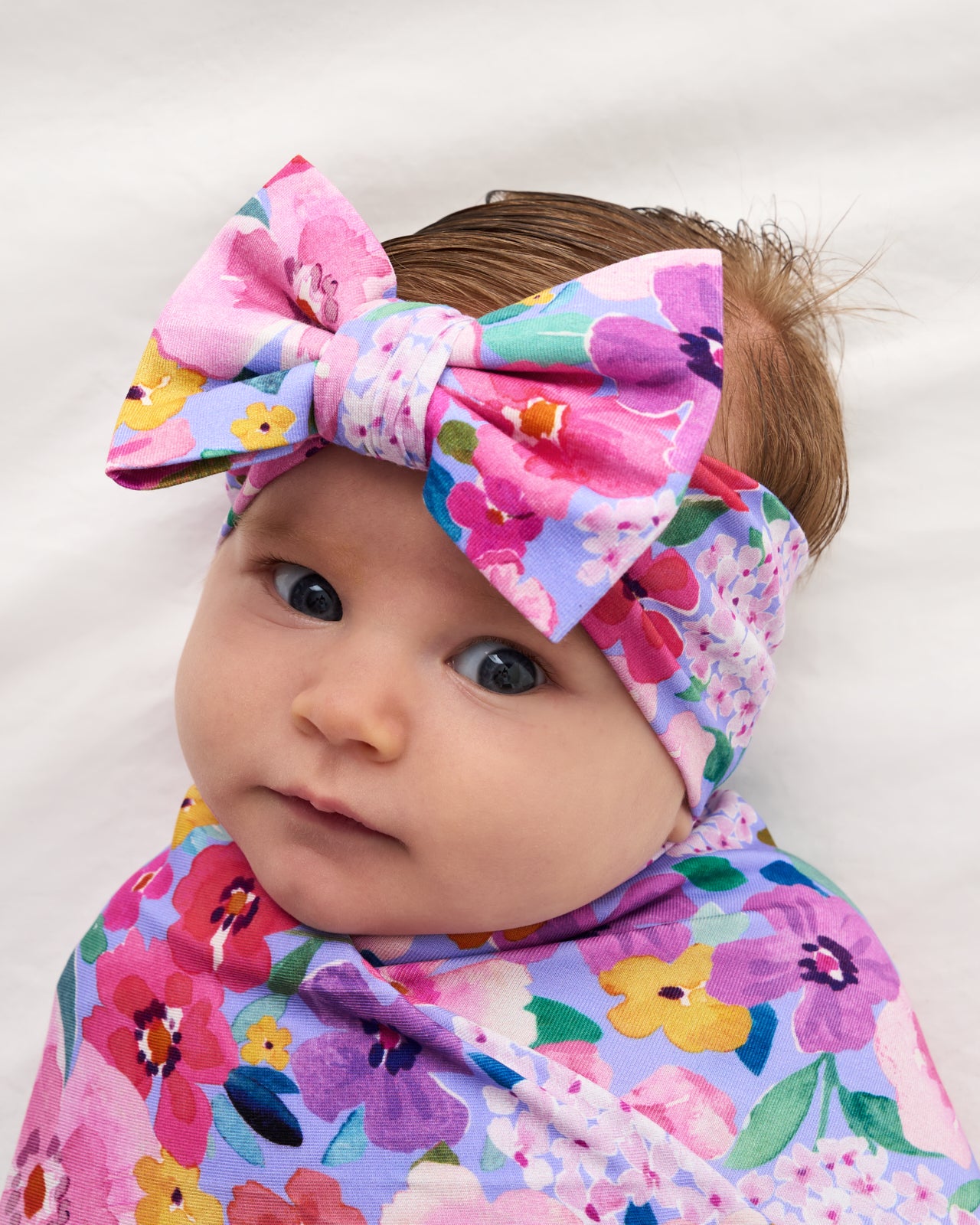 Close up of baby wearing the Sweet Sprigs Swaddle & Luxe Bow Headband Set