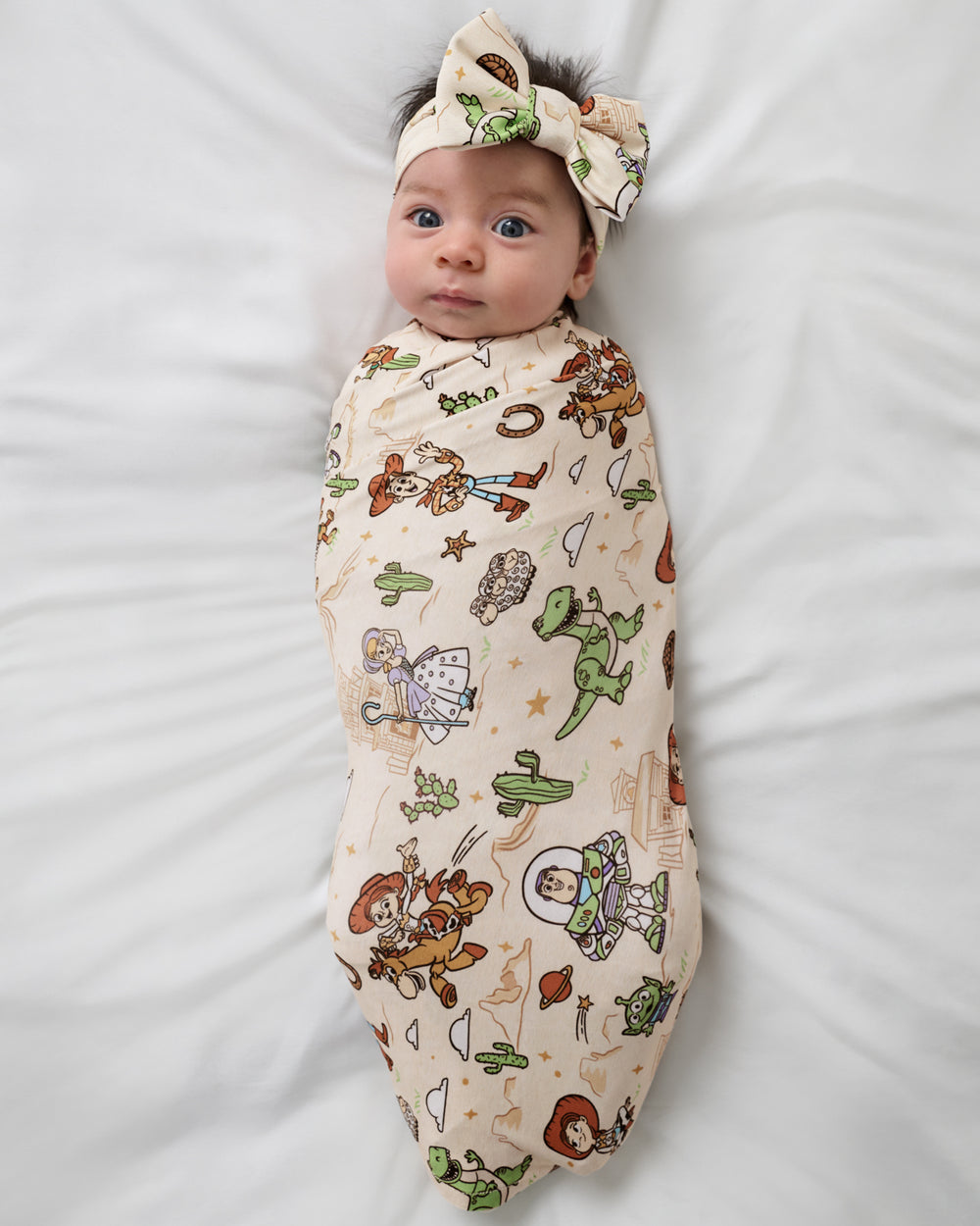 Aerial view of the Disney & Pixar Woody's Wild West Swaddle & Luxe Bow Headband Set